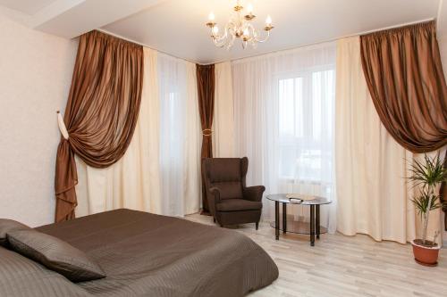 ニジニ・ノヴゴロドにあるСутки-Дом - Новаяのベッドルーム1室(ベッド1台、椅子、シャンデリア付)