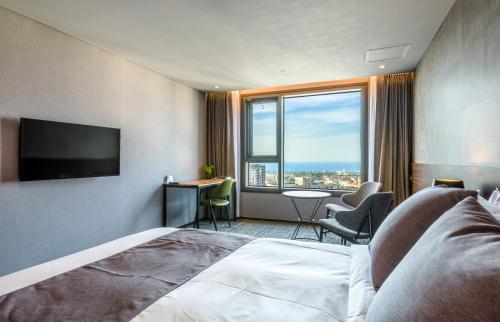 pokój hotelowy z łóżkiem i dużym oknem w obiekcie Hotel With Jeju w mieście Czedżu