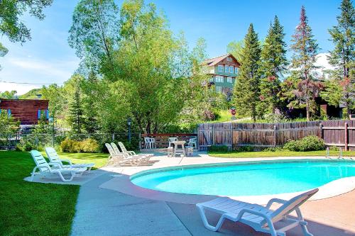 a swimming pool with chairs and a table at Nordic Lodge in Steamboat Springs