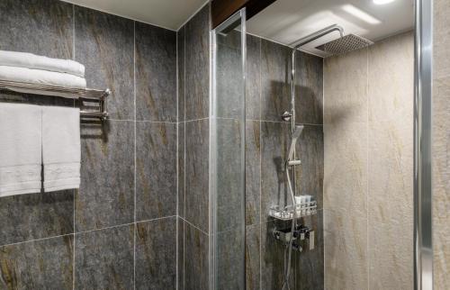 a bathroom with a shower with a glass door at Hotel With Jeju in Jeju