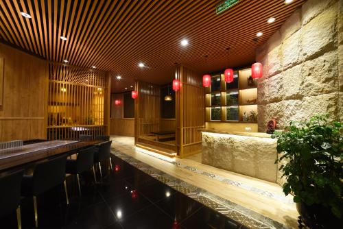 a restaurant with a bar with chairs and lights at Millennium Harbourview Hotel Xiamen-Near Metro Station & Zhongshan Road in Xiamen
