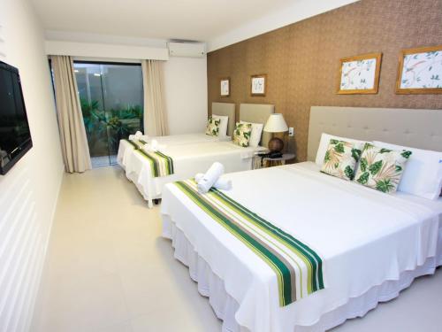 En eller flere senge i et værelse på Hotel Premium Recanto da Passagem