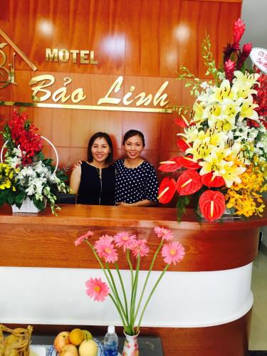 two women sitting in front of a mirror with flowers at Motel Bao Linh in Vung Tau