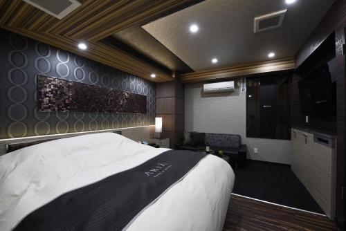 a bedroom with a large bed and a television at Hotel Aria(Adult Only) in Chiba