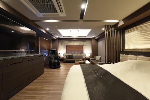 a hotel room with a bed and a living room at Hotel Aria(Adult Only) in Chiba