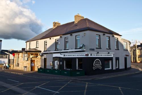 a large white building on the corner of a street at Maddens Bridge Bar & Guesthouse in Bundoran