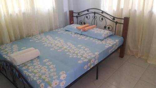 a bed with blue sheets with flowers on it at D downhill'Place in Oslob