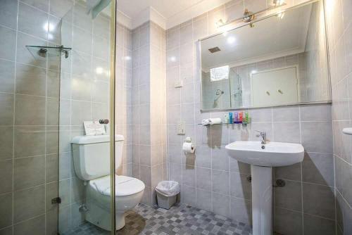 La salle de bains est pourvue de toilettes et d'un lavabo. dans l'établissement Seaside Garden Retreat Accommodation, à Wamberal