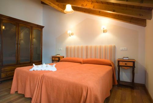 a bedroom with a large orange bed in a room at La Fonda de Bustio in Bustio