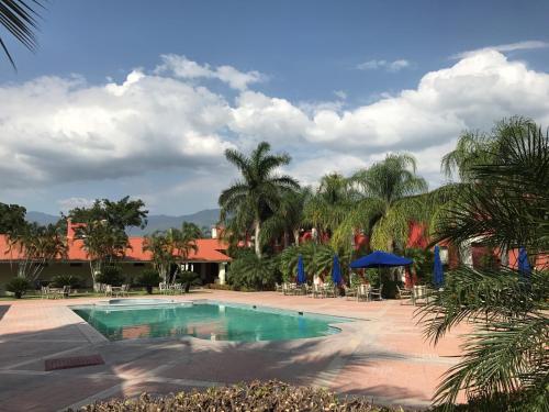 a pool at a resort with palm trees at Hotel Santa Maria de Comayagua in Comayagua