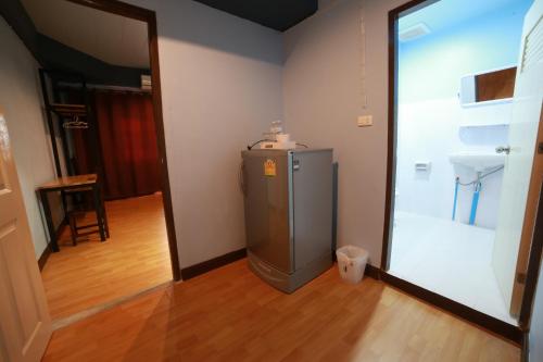 nevera pequeña en una habitación con espejo en M Place, en Ban Kao