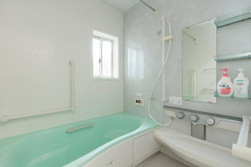 a white bathroom with a tub and a sink at Calligraphy House in Kyoto