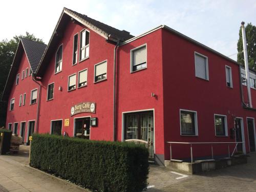 un edificio rosso con un edificio rosso di Bergcafè - Hotel Kammann a Essen
