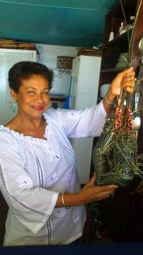 a woman in a kitchen holding a purse at Remo e Berenice in Nosy Komba