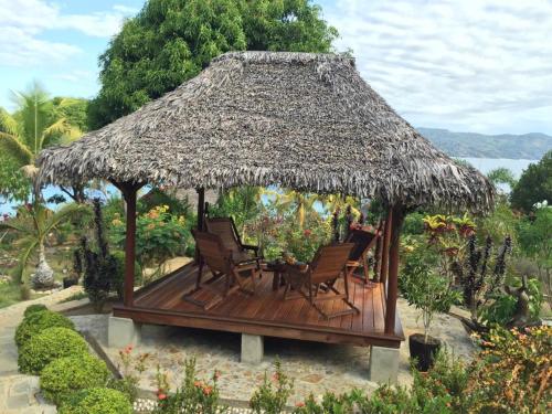 a gazebo with chairs and a straw roof at Remo e Berenice in Nosy Komba