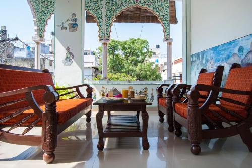 a room with benches and a table and a window at Hotel Rising Star in Pushkar