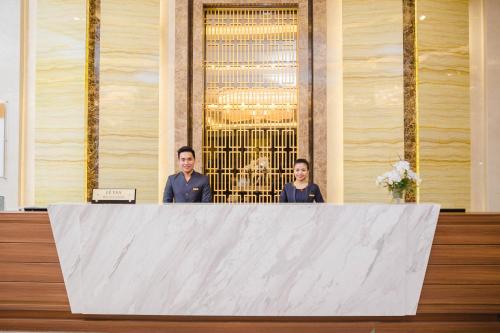 a man and woman standing behind a large white table at Muong Thanh Luxury Bac Ninh Hotel in Bắc Ninh