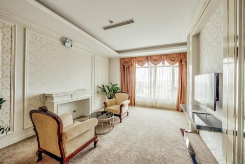 a living room with two chairs and a television at Muong Thanh Luxury Bac Ninh Hotel in Bắc Ninh
