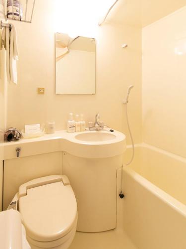 a bathroom with a toilet and a sink and a tub at Pearl Hotel Ryogoku in Tokyo