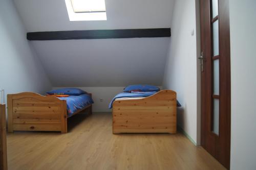 two beds in a small room with a window at Pokoje Gościnne "U Karola" Pracownicze in Ścinawa