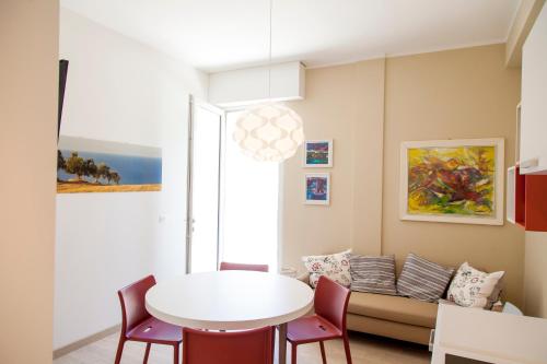 a living room with a table and a couch at Casa Prima Fila Mare in Porto San Giorgio