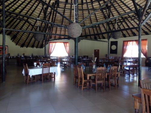 a dining room with tables and chairs in a building at Xain Quaz Camp in Gobabis
