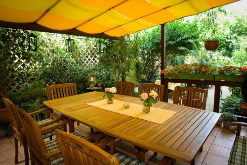 a wooden table with chairs and an umbrella at Hotel Azenberg in Stuttgart