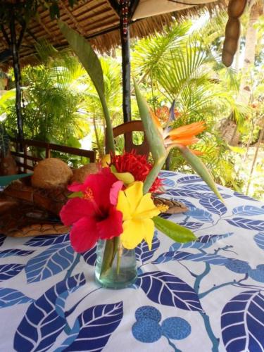 a vase filled with colorful flowers on a table at Remo e Berenice in Nosy Komba