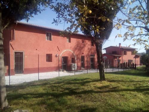 un edificio arancione con una recinzione di fronte di La Bettola Tavern Rooms & Restaurant a Montopoli in Val dʼArno