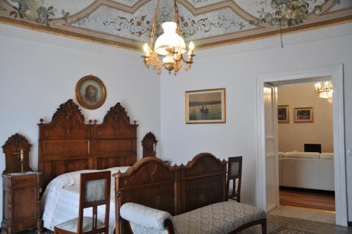 1 dormitorio con cama de madera y lámpara de araña en Casa Sipione Papa, en Módica