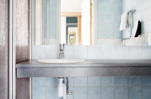 La salle de bains est pourvue d'un lavabo et d'un miroir. dans l'établissement Comfort Hotel Arctic, à Luleå