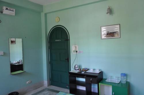 a room with a green door and a table at Saikia Nest the Home-stay in Guwahati