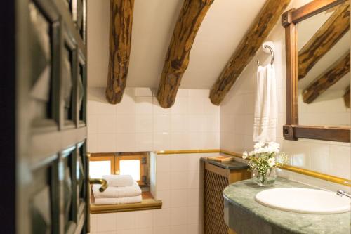 bagno con lavandino e specchio di CALERILLA Hotel a Burunchel