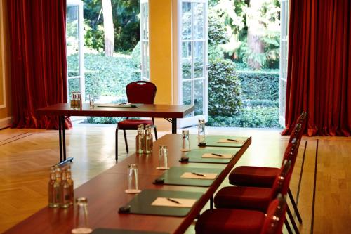 a dining room with a long table and chairs at Hotel Bad Schachen in Lindau