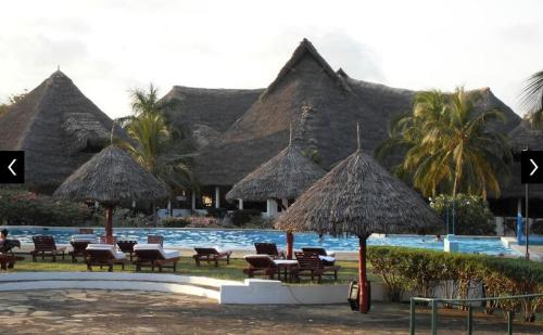 マリンディにあるFlappy Beach Villa Malindi Mambruiのリゾート(椅子、パラソル、スイミングプール付)