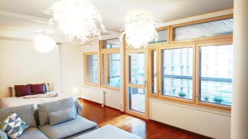 sala de estar con ventanas, sofá y lámparas de araña en Superb Location + Silence + Sauna, en Helsinki