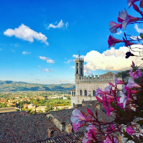a building with a clock tower on top of a city at Relais Ducale in Gubbio