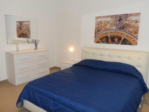 a white bedroom with a blue bed and a dresser at Residence Rapisardi by RECEPTIO in Catania