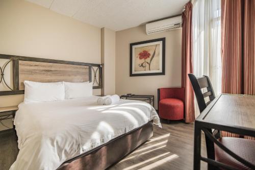 Habitación de hotel con cama y escritorio en Hotel 224 & Apartments, en Pretoria