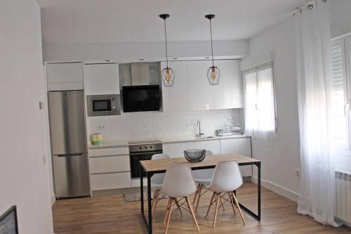 a kitchen with a table and two white chairs at G&D Vivienda Turística in Logroño