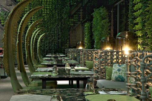 a row of tables in a restaurant with vines at arTree hotel in Taipei