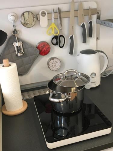 a kitchen counter with a pot on a stove with utensils at Centra and simple to reach in Vienna