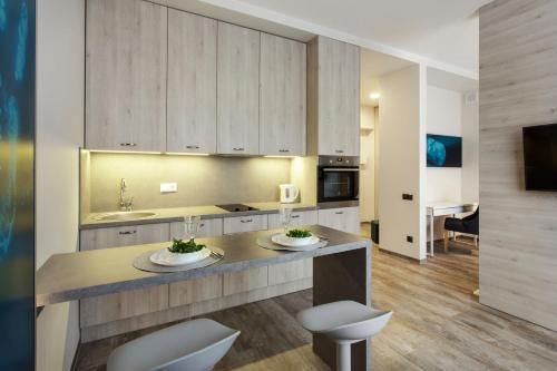 a kitchen with a counter with two chairs and a sink at Old Town Trio Apartments in Vilnius