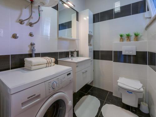 białą pralkę w łazience z umywalką w obiekcie Apartments Livaja w Crikvenicy