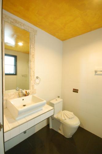 a bathroom with a sink and a toilet and a mirror at SHA The Regent Resort Phuket Kamala Beach in Kamala Beach