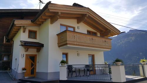 a house with a balcony with a table at Glaserhof in Gerlosberg