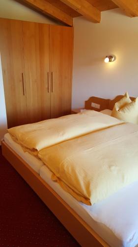 a bedroom with a large bed with wooden cabinets at Glaserhof in Gerlosberg