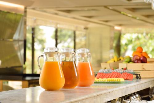 three glass mason jars filled with orange juice on a counter at Regal Kowloon Hotel in Hong Kong