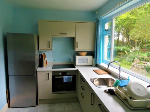 a kitchen with a sink and a refrigerator and a window at Nordor - lots of parking in Portland