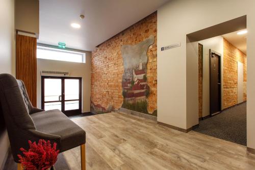a waiting room with a chair and a brick wall at Old Town Trio Apartments in Vilnius